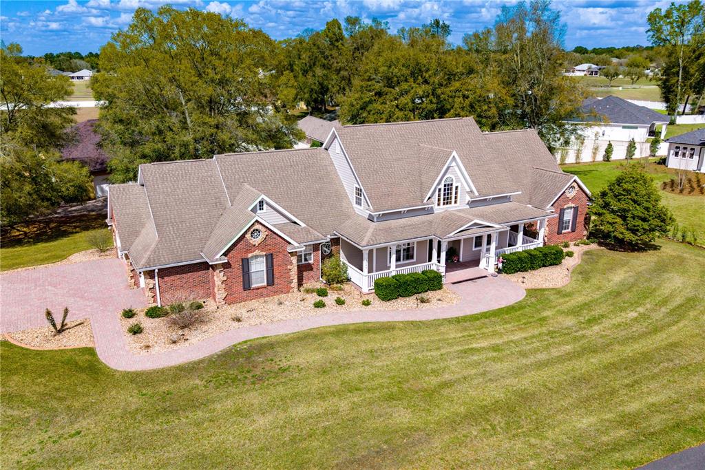 An aerial view of a brick and siding house with a large roof and driveway — 5795 SW 43RD PLACE, OCALA, FL