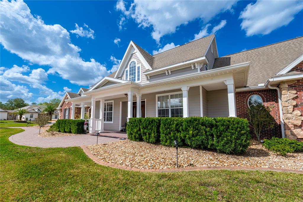 A single-story house with a gray exterior, brick accents, and a covered front porch — 5795 SW 43RD PLACE, OCALA, FL