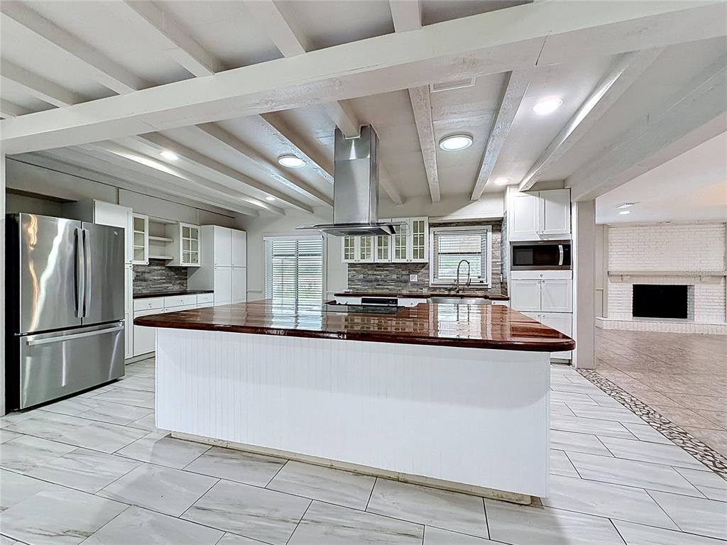 A single-story house with a green metal roof, tan stucco walls, and a red front door — 912 SHANGRI LA DRIVE, SEFFNER, FL