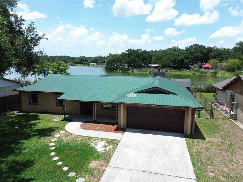 A kitchen features a large wooden island, white cabinetry, stainless steel appliances, and exposed ceiling beams — 912 SHANGRI LA DRIVE, SEFFNER, FL