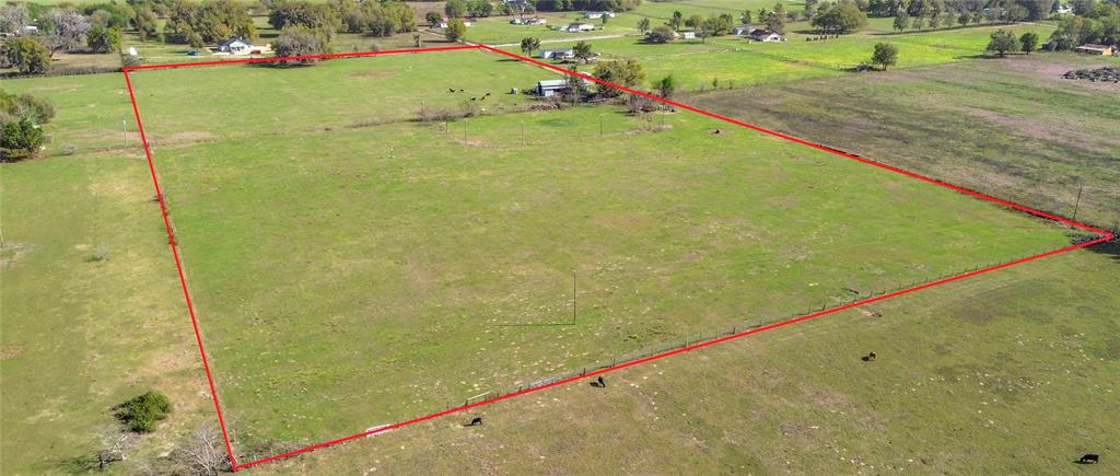 An aerial view shows a fenced rural property with a pole barn and a lighted arena — 855 NE 107TH ROAD, OXFORD, FL