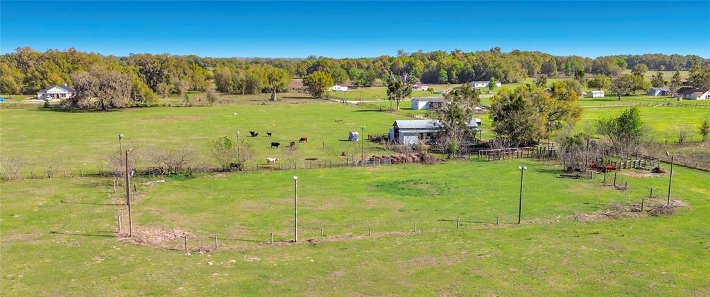 An aerial view shows a large, fenced pasture with several buildings and scattered trees — 855 NE 107TH ROAD, OXFORD, FL