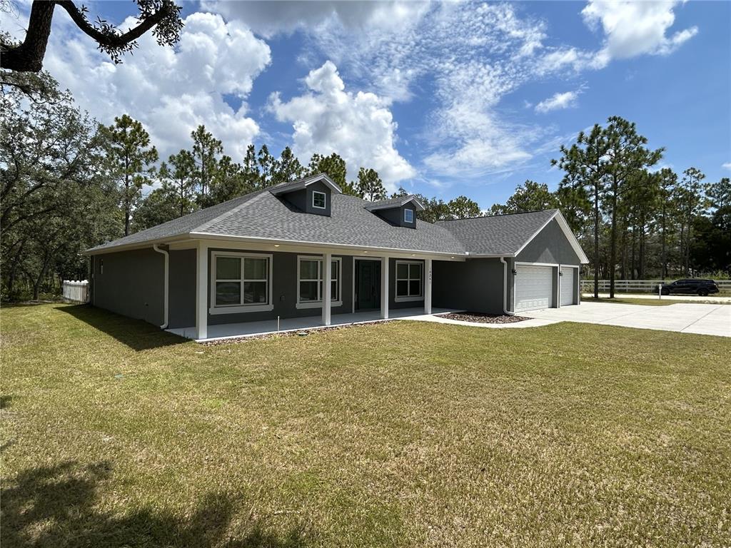 A gray, single-story house with a covered front porch and two dormer windows — 10361 THRASHER AVENUE, WEEKI WACHEE, FL
