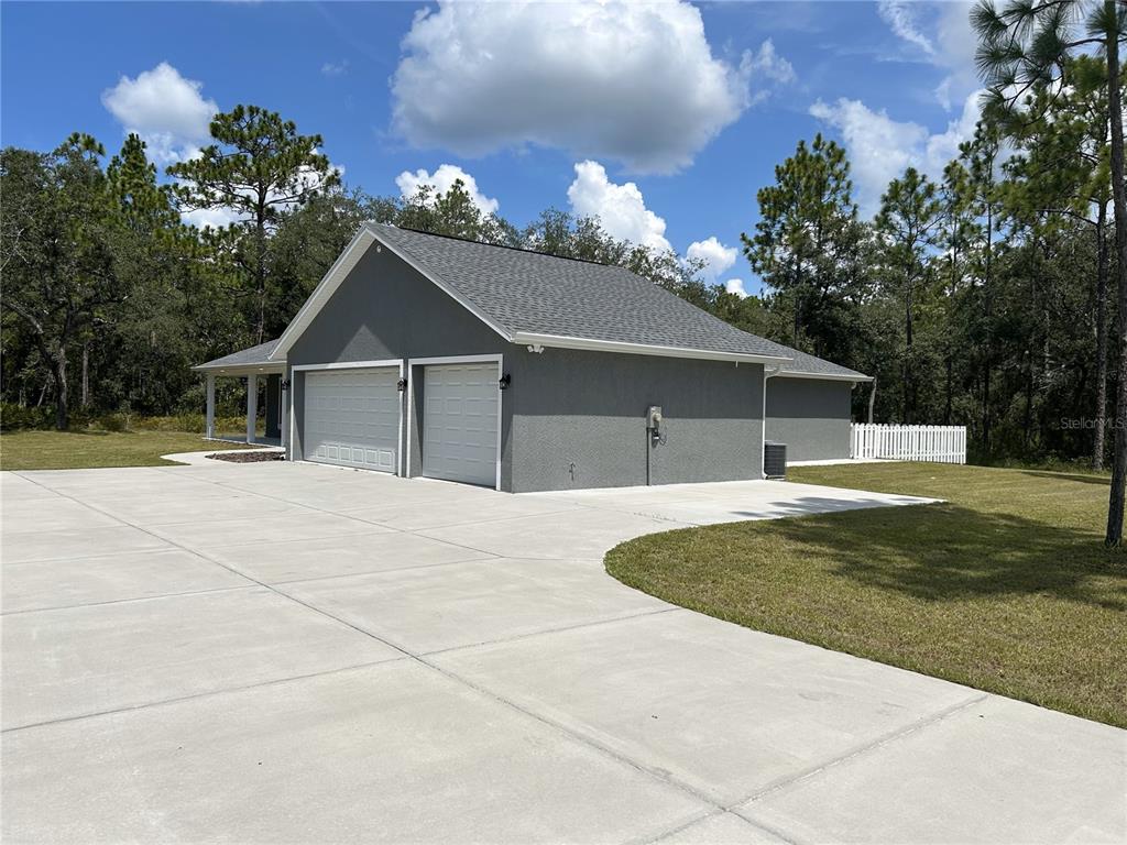 A gray house with a two-car garage and a large concrete driveway — 10361 THRASHER AVENUE, WEEKI WACHEE, FL