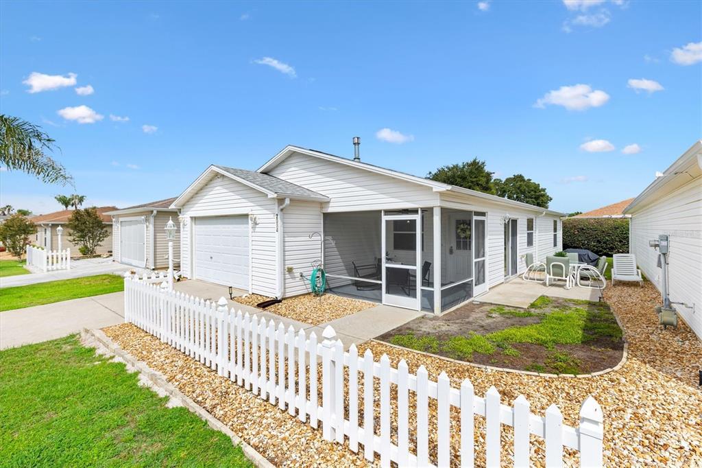 A white house with a screened-in porch, a garage, and a white picket fence — 2014 JOHNSON COURT, THE VILLAGES, FL