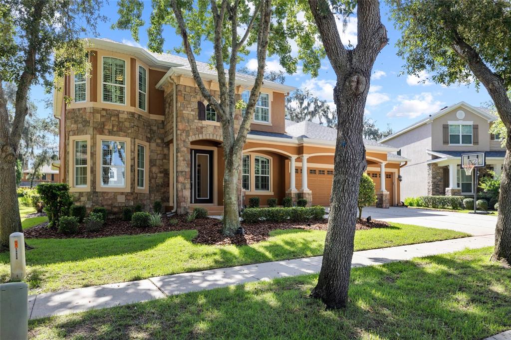 A two-story house with a stone facade, brown stucco, and a three-car garage — 15910 TERNGLADE DRIVE, LITHIA, FL