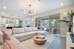 A living room with a sectional sofa, round coffee table, and sliding doors to a patio — 3160 FIRETHORN CIRCLE, DAYTONA BEACH, FL