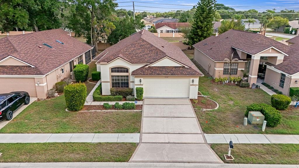 An aerial view of a suburban house with a brown roof and a concrete driveway — 9147 JIMINEZ DRIVE, HUDSON, FL