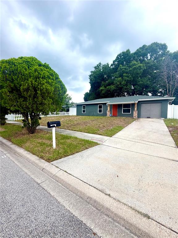 A single-story house with a gray exterior, a red front door, and a concrete driveway — 464 NEW MEADOWS COURT, OCOEE, FL