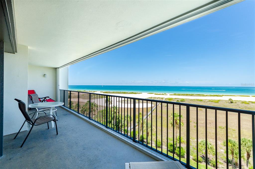 An aerial view of a multi-story beachfront condominium building with a red arrow pointing toward a balcony — 1250 GULF BOULEVARD UNIT 703, CLEARWATER BEACH, FL