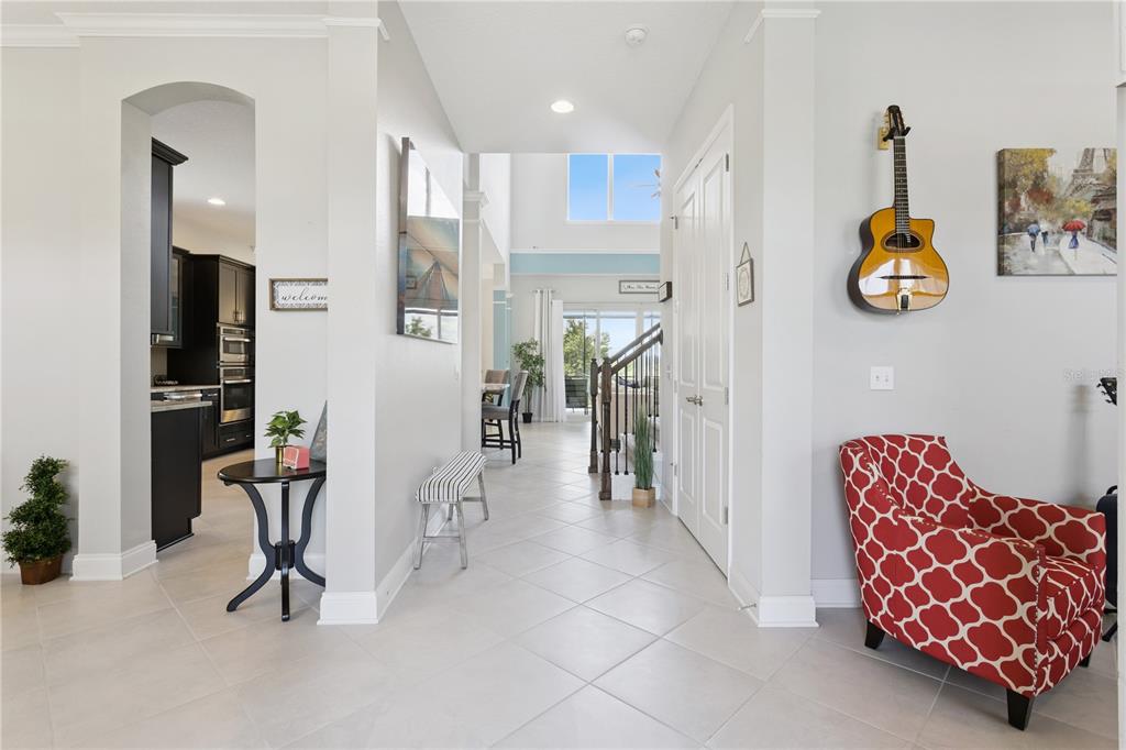 A home office features a piano, a desk, a patterned armchair, and guitars on the walls — 16416 GOOD HEARTH BOULEVARD, CLERMONT, FL