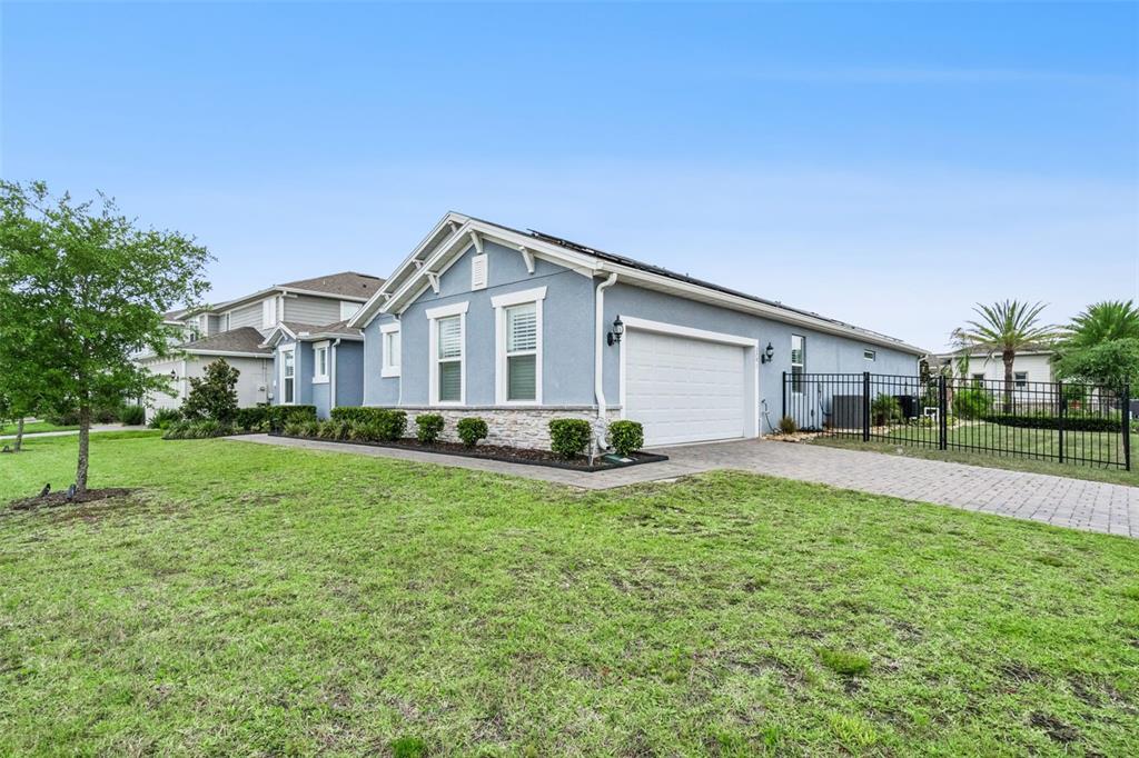A light blue single-story house with a two-car garage and a black metal fence — 2701 TIMBERGROVE STREET, ST CLOUD, FL