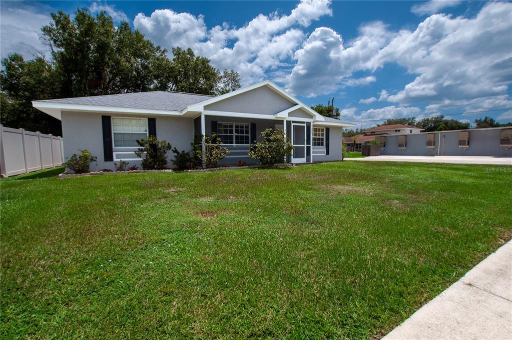 A single-story gray house with a front porch and a large grassy lawn — 1204 E GIBSON STREET, ARCADIA, FL