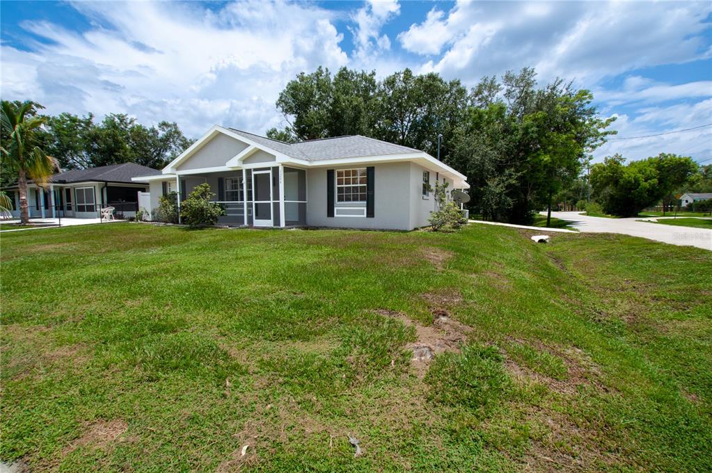 A single-story gray house with a screened front porch sits on a grassy lot — 1204 E GIBSON STREET, ARCADIA, FL