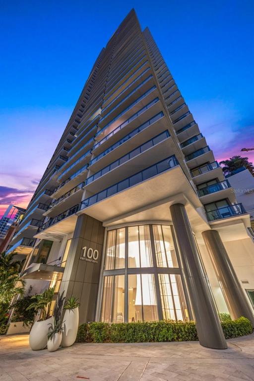 A low-angle exterior view of a modern high-rise residential building at dusk — 100 1ST AVENUE N UNIT 1603, ST PETERSBURG, FL