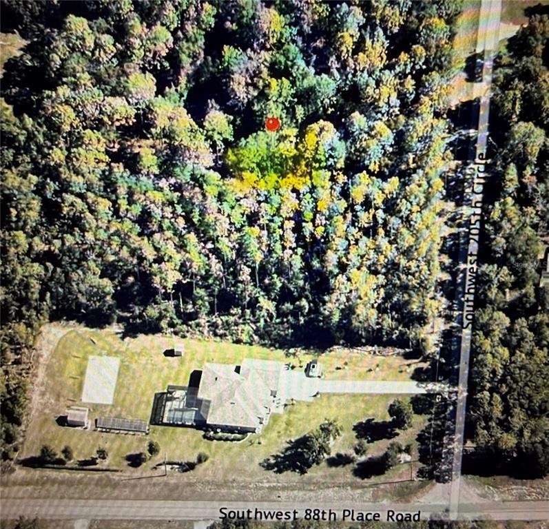 An aerial view shows a house with a large yard and a wooded lot — SW 205TH CIRCLE, DUNNELLON, FL
