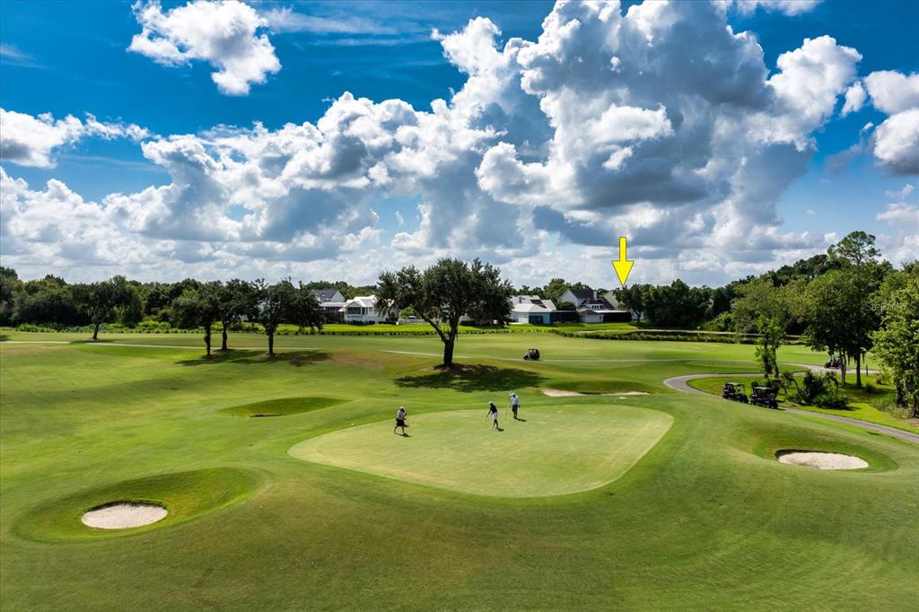 An aerial view of a golf course green with golfers and houses in the background — 915 JASMINE STREET, CELEBRATION, FL