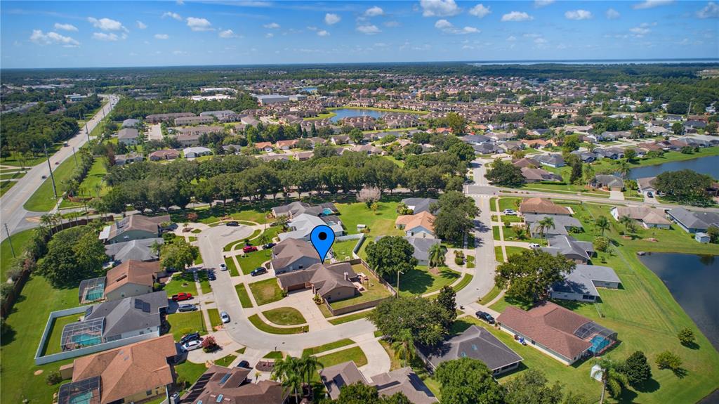 A single-story suburban house with a large driveway, attached garage, and a wooden privacy fence — 5719 SWEETHEART COURT, ST CLOUD, FL