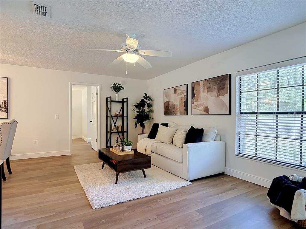 A covered patio with a brick floor overlooks a screened-in swimming pool and spa — 3208 LAKE HELEN OSTEEN ROAD, DELTONA, FL