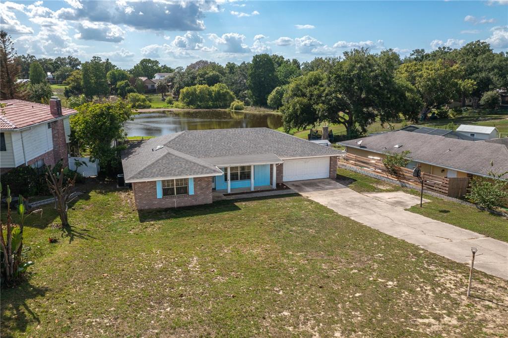 An aerial view of a single-story brick house with a gray roof and attached garage — 136 LAKE RING DRIVE, WINTER HAVEN, FL