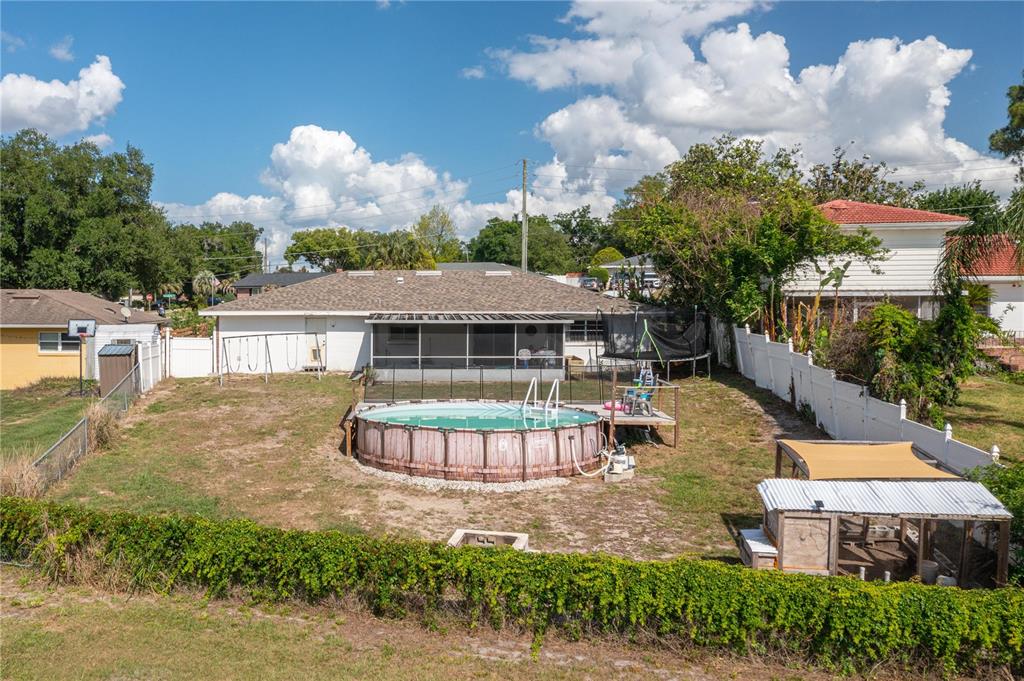 An aerial view of a backyard featuring an above-ground pool, a chicken coop, and fencing — 136 LAKE RING DRIVE, WINTER HAVEN, FL