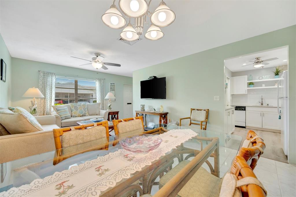 A kitchen features white cabinets, light countertops, a white stove, and a subway tile backsplash — 6057 CORAL WAY UNIT 3, BRADENTON, FL