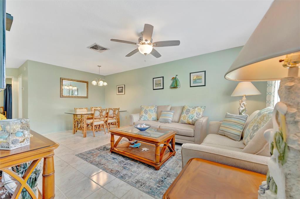 A lamp with a bird-shaped base sits on a table in a light-green entryway — 6057 CORAL WAY UNIT 3, BRADENTON, FL