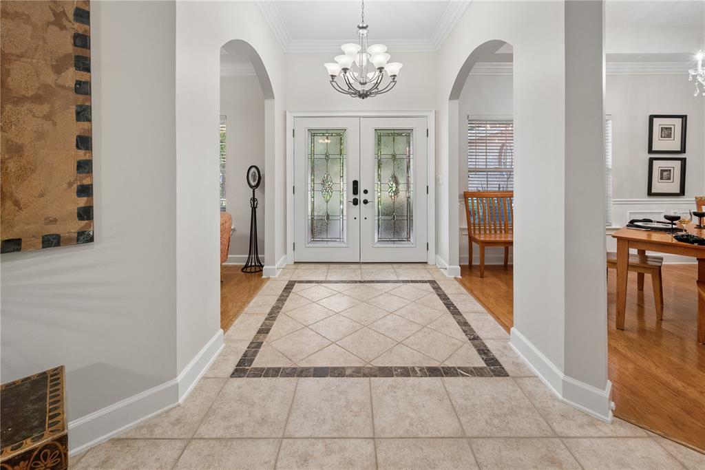 A foyer features a tiled floor with a decorative border, arched entryways, and double doors — 104 BELMONT DRIVE, ST JOHNS, FL
