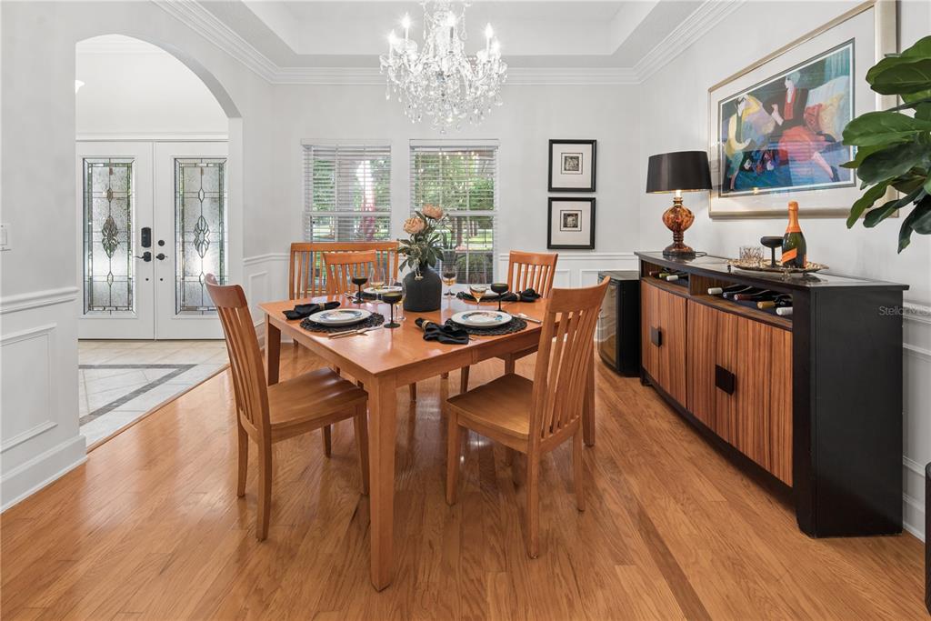 A dining room features a wooden table, chairs, a chandelier, and a sideboard on hardwood floors — 104 BELMONT DRIVE, ST JOHNS, FL