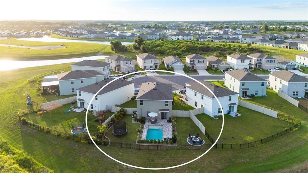 A two-story suburban house features a tan stucco exterior, a two-car garage, and landscaping — 10016 BIG MARSH TERRACE, PARRISH, FL