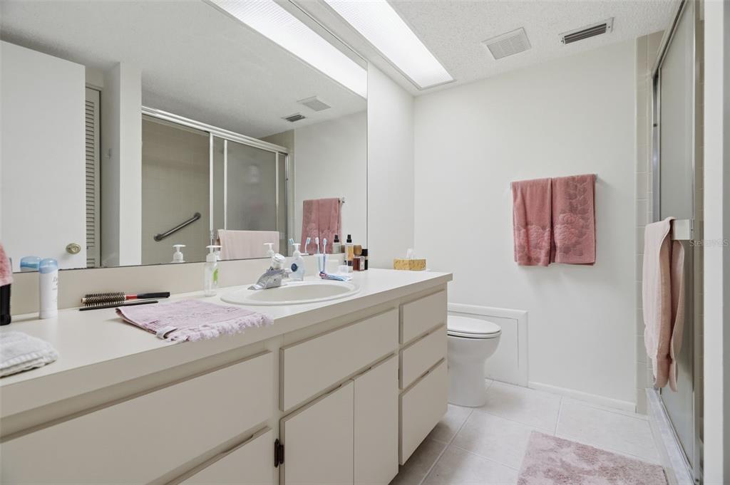 A single-story tan stucco and wood-sided townhouse with a front walkway and small garden beds — 3828 SAILMAKER LANE, HOLIDAY, FL