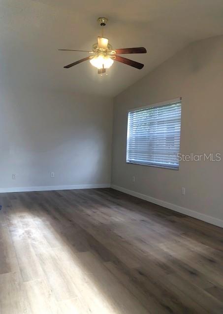 An empty room with light wood-look flooring, a ceiling fan, and a window with blinds — 2419 CEDAR AVENUE UNIT B, SANFORD, FL