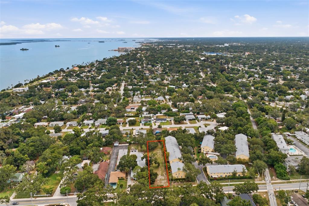 An aerial view shows a vacant, rectangular lot outlined in red within a residential neighborhood — SUNSET POINT ROAD, CLEARWATER, FL