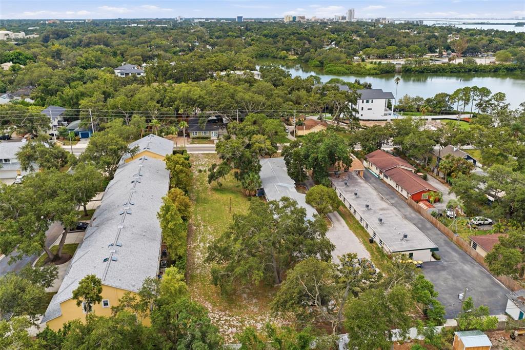 An aerial view shows two long apartment buildings separated by a grassy lot and trees — SUNSET POINT ROAD, CLEARWATER, FL