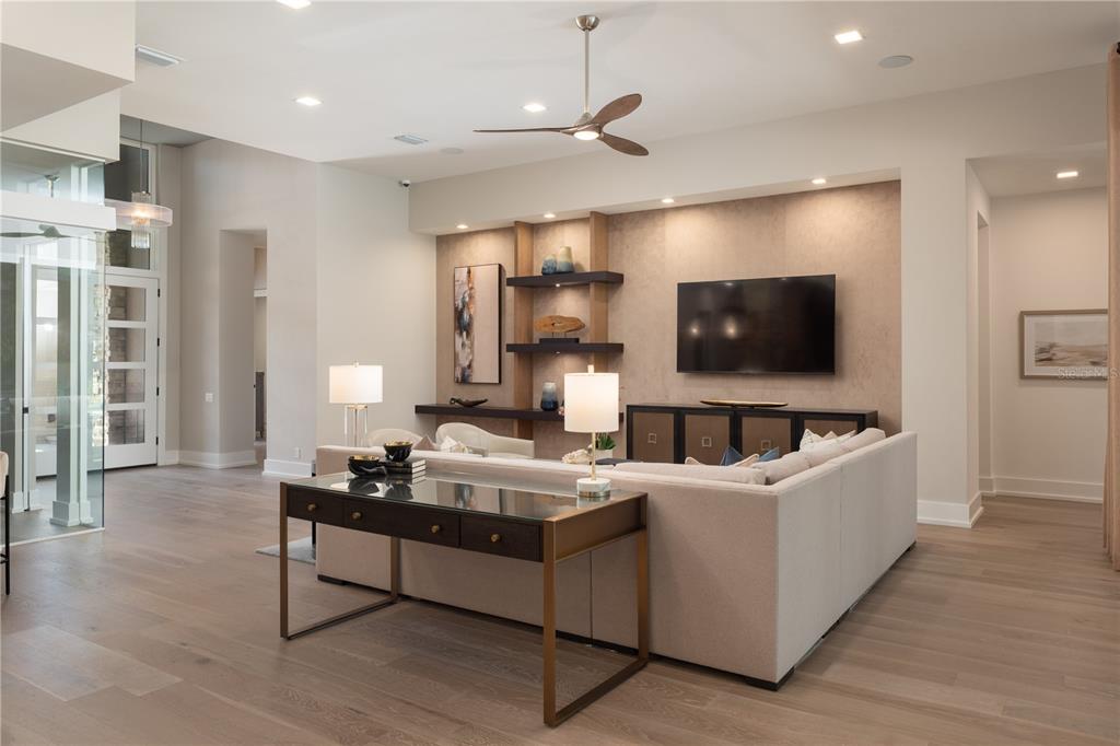 A modern living room features a large sectional sofa, a console table, and built-in shelving — 3120 SW 108TH WAY, GAINESVILLE, FL