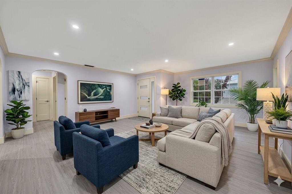A living room features light purple walls, a beige sectional, two blue armchairs, and flooring — 870 NARCISSUS AVENUE, CLEARWATER BEACH, FL