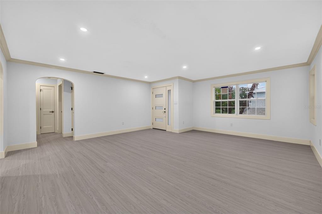 An empty room with light gray walls, wood-look flooring, recessed lighting, and a front door — 870 NARCISSUS AVENUE, CLEARWATER BEACH, FL