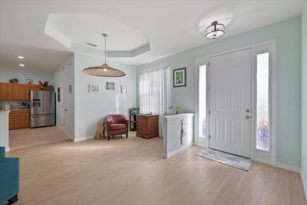 A foyer with light wood flooring leads to an open kitchen with stainless steel appliances — 8 ABAFT PLACE, PLACIDA, FL