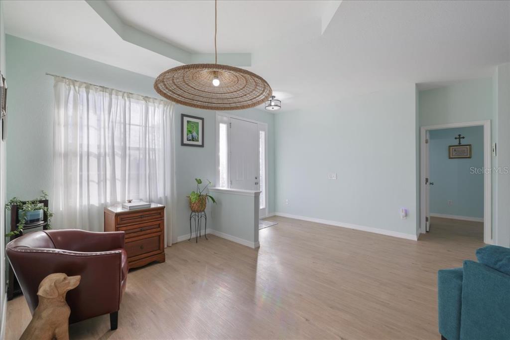 A light-walled living room features wood-look flooring, a large woven pendant light, and an entryway — 8 ABAFT PLACE, PLACIDA, FL