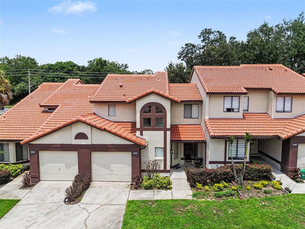 A multi-unit residential building with a tiled roof, stucco exterior, and attached garages — 3336 GRAY FOX COVE UNIT 3336, APOPKA, FL
