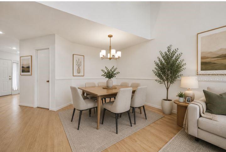A dining area with a wooden table, six chairs, and a chandelier on light flooring — 3336 GRAY FOX COVE UNIT 3336, APOPKA, FL
