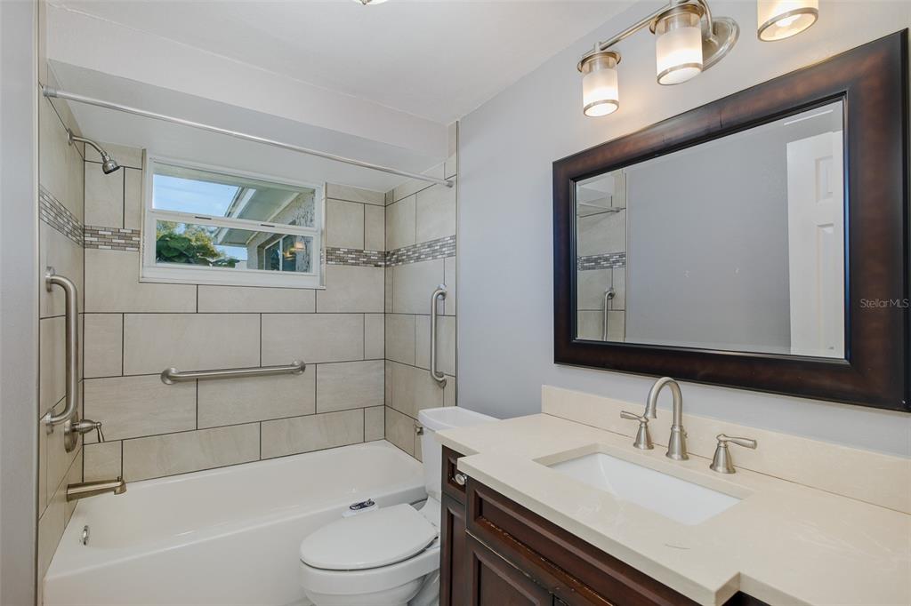A kitchen with white cabinets, granite countertops, stainless steel appliances, and light tile flooring — 1148 FERNWOOD DRIVE, HOLIDAY, FL