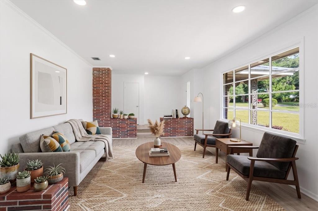 A living room features a grey sofa, two armchairs, a coffee table, and brick accents — 2107 GOLF DRIVE, PALATKA, FL