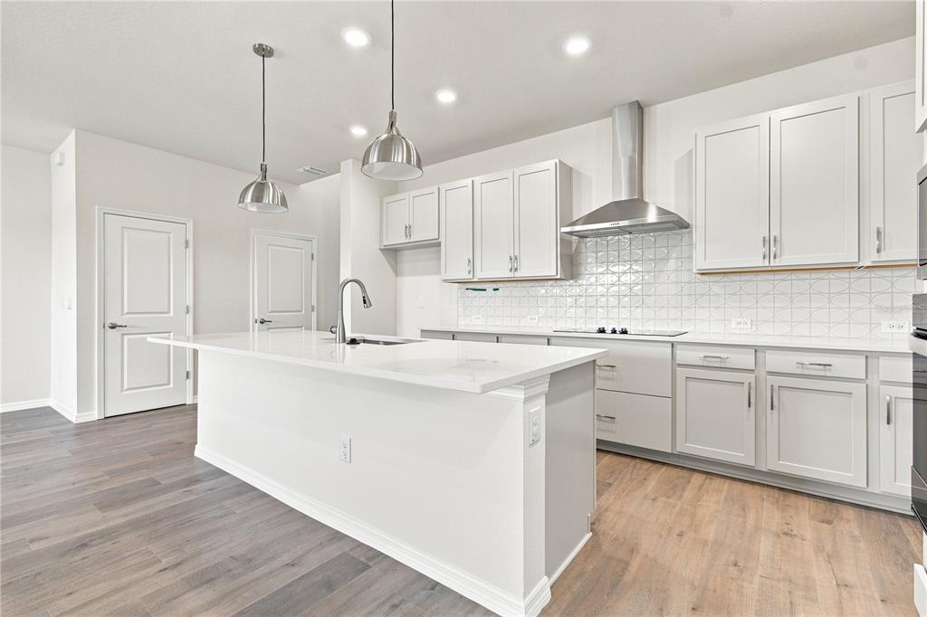 A two-story house under construction features a light green exterior, white trim, and an open garage — 3435 YELLOW CASSIA DRIVE, WESLEY CHAPEL, FL