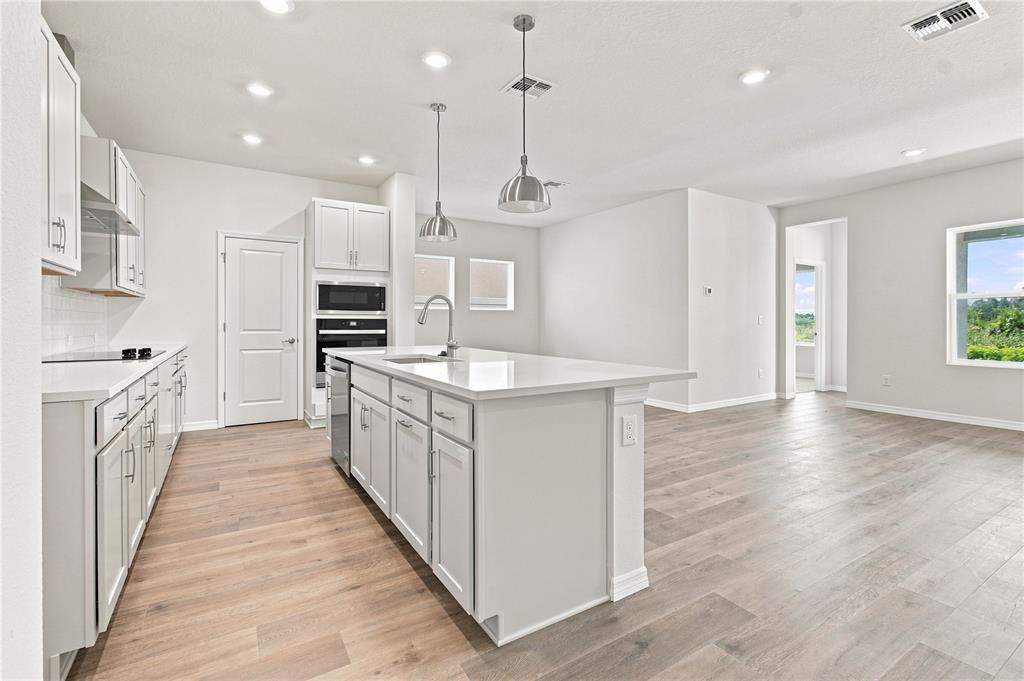 This floor plan shows a single-story home layout with a garage, kitchen, and five bedrooms — 3435 YELLOW CASSIA DRIVE, WESLEY CHAPEL, FL