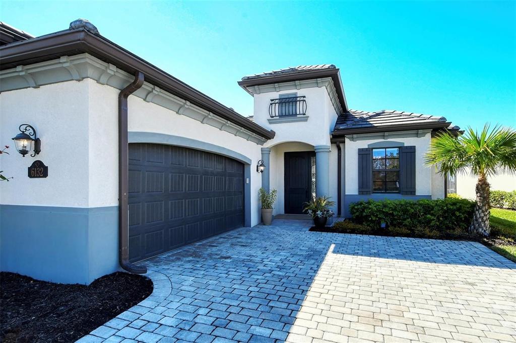 A single-story house exterior features a two-car garage, a paved driveway, and a front entrance — 6132 CESSNA RUN, BRADENTON, FL