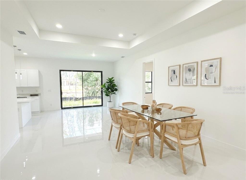 A dining area features a glass table, rattan chairs, white tile floors, and sliding doors — 4322 KISMET PARKWAY W, CAPE CORAL, FL
