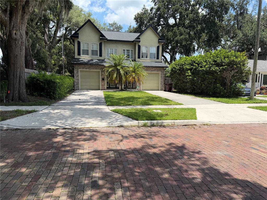 A two-story house with a brick and stucco facade, two garages, and a front palm tree — 1009 ELMWOOD STREET UNIT 1009, ORLANDO, FL