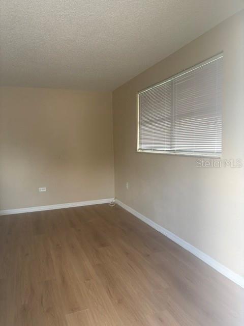 An empty room features light-colored walls, wood-look flooring, and a window with white blinds — 3021 OAKLAWN AVENUE UNIT A, LARGO, FL
