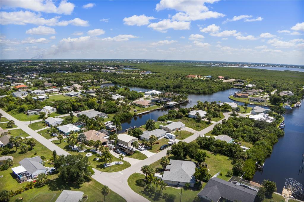 An aerial view of a residential neighborhood with houses situated along canals and lush greenery — 19154 NEW HAVEN COURT, PORT CHARLOTTE, FL